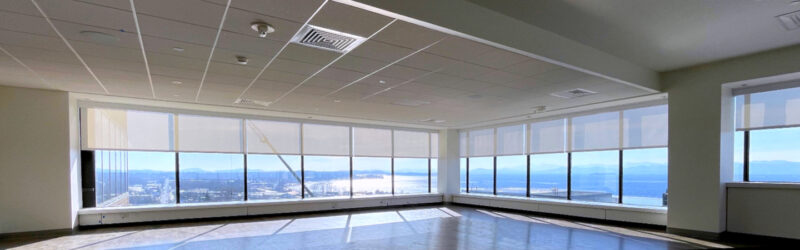 EcoSmart white commercial roller shades in corner office space overlooking Lake Champlain