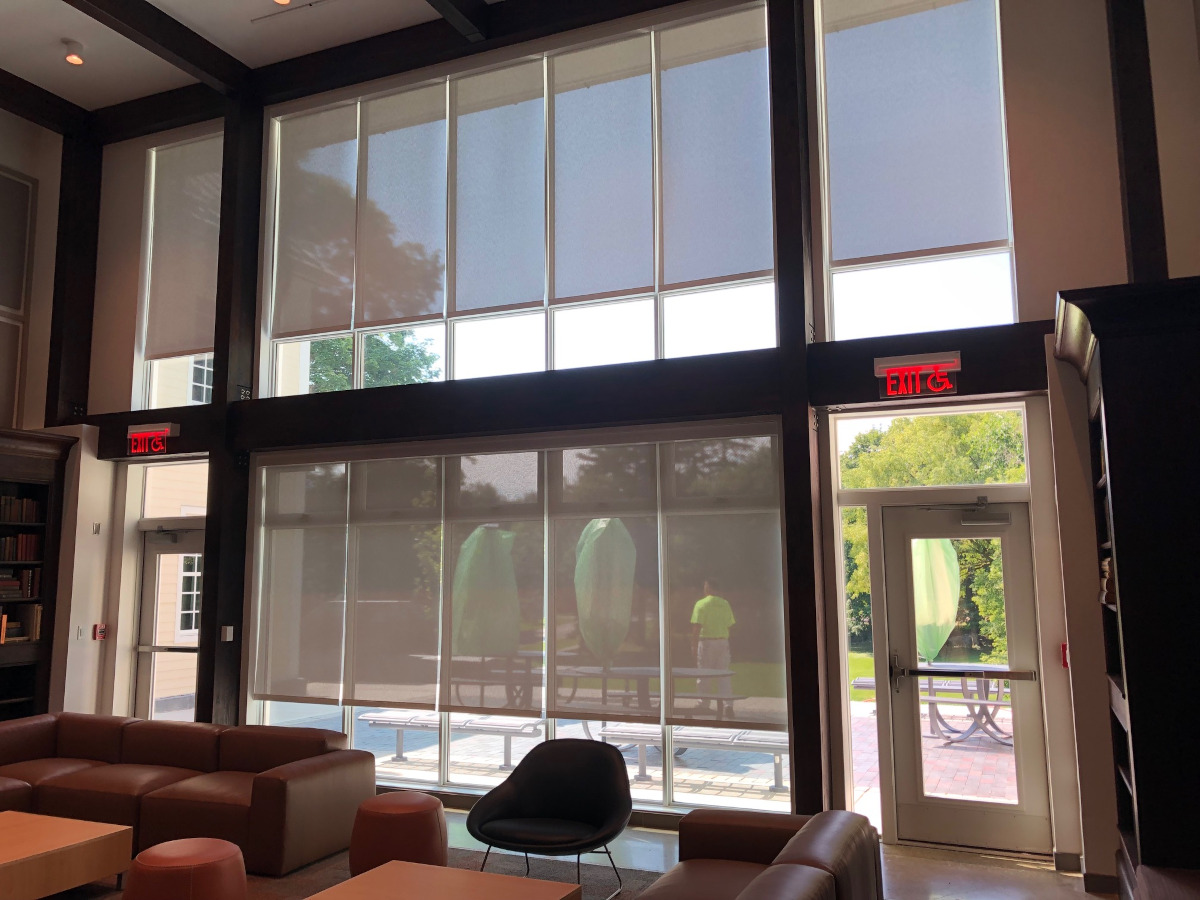 Commercial EcoSmart solar shades in hotel lobby with view of pool
