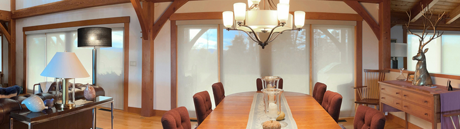 EcoSmart custom roller shades in white over sliding glass doors in open-concept dining room and living room